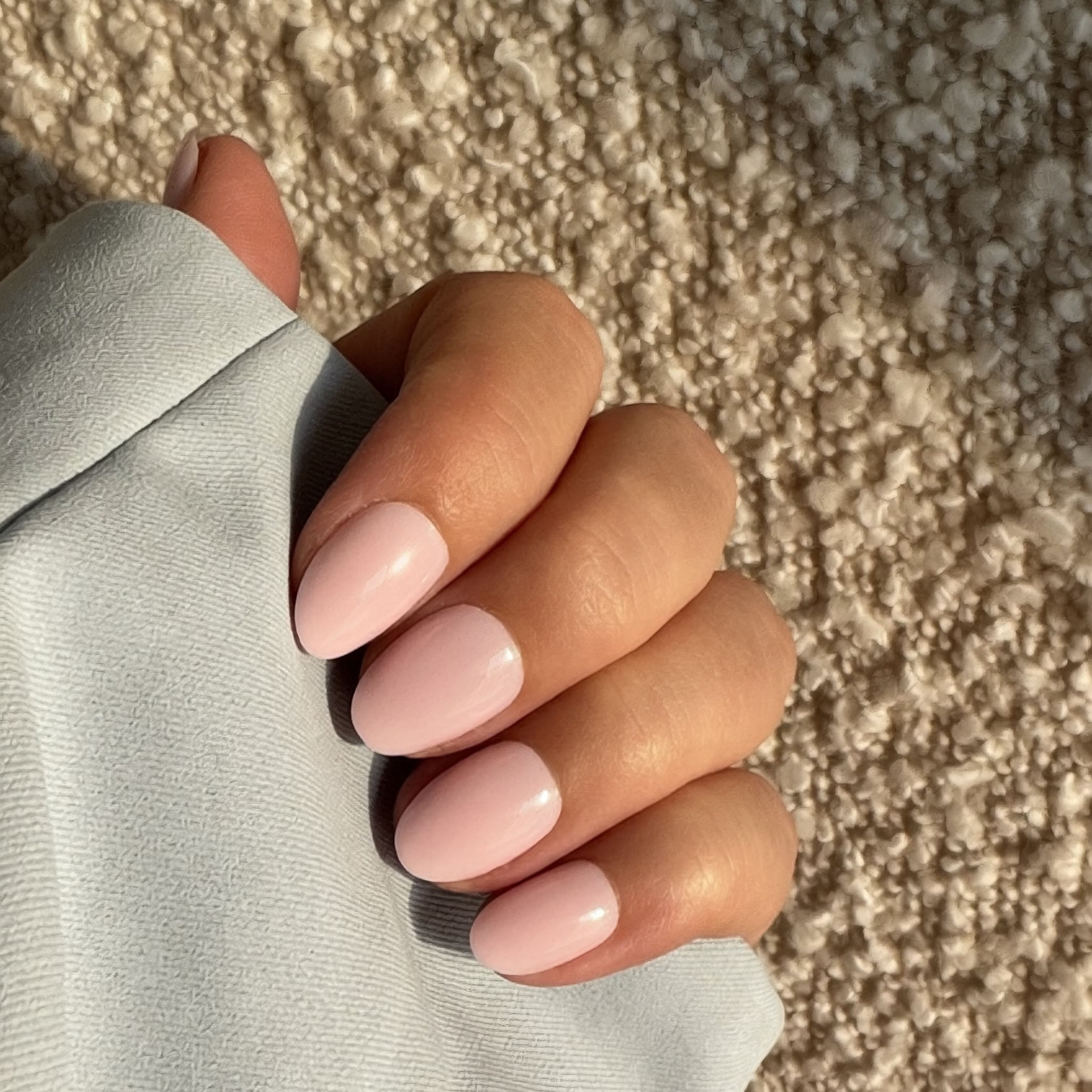 Hand wearing Instant Mani Co light pink press on nails