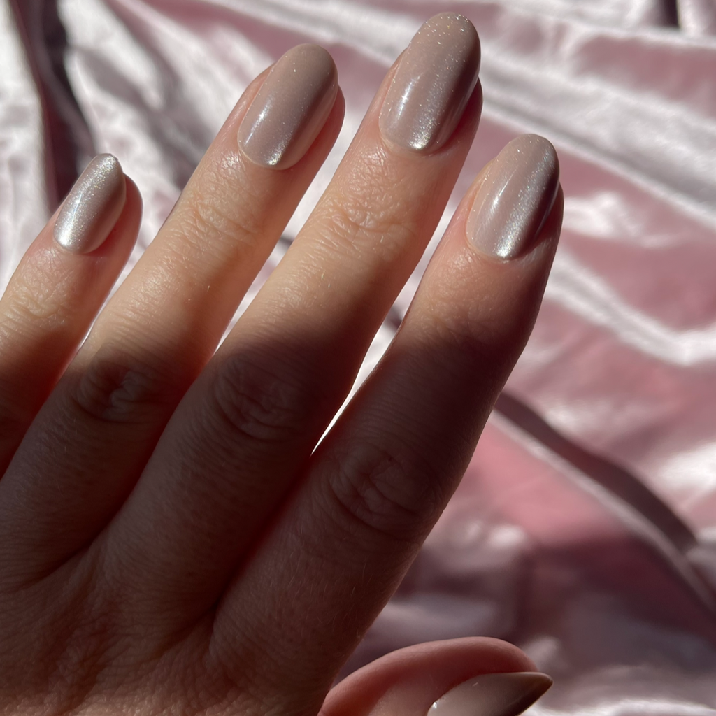 Girl wearing Instant Mani Co. Golden Hour press on nails, in front of velvet pink background 