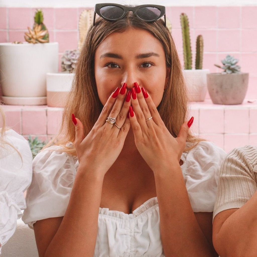 Three girls posing as the think no evil, speak no evil, hear no evil, while sitting down wearing Instant Mani Co press-on nails