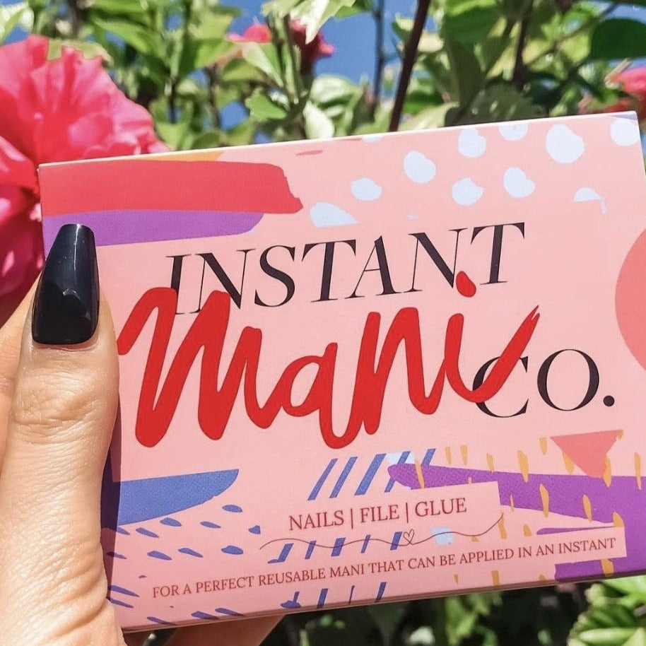 Girl wearing Instant Mani Co. Black press on nails in medium length.