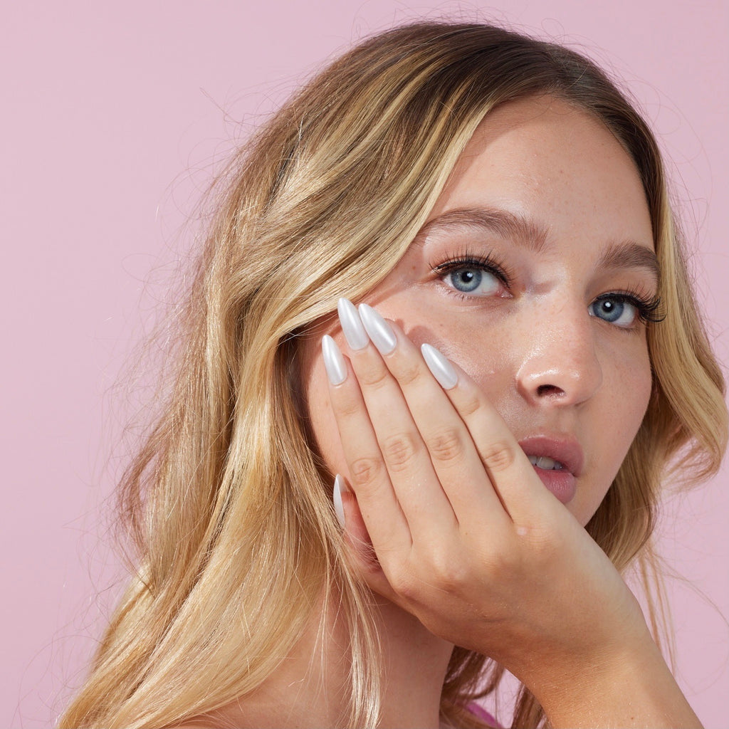 Girl standing in front of pink background wearing Instant Mani Co. Sugar Rush press on nails