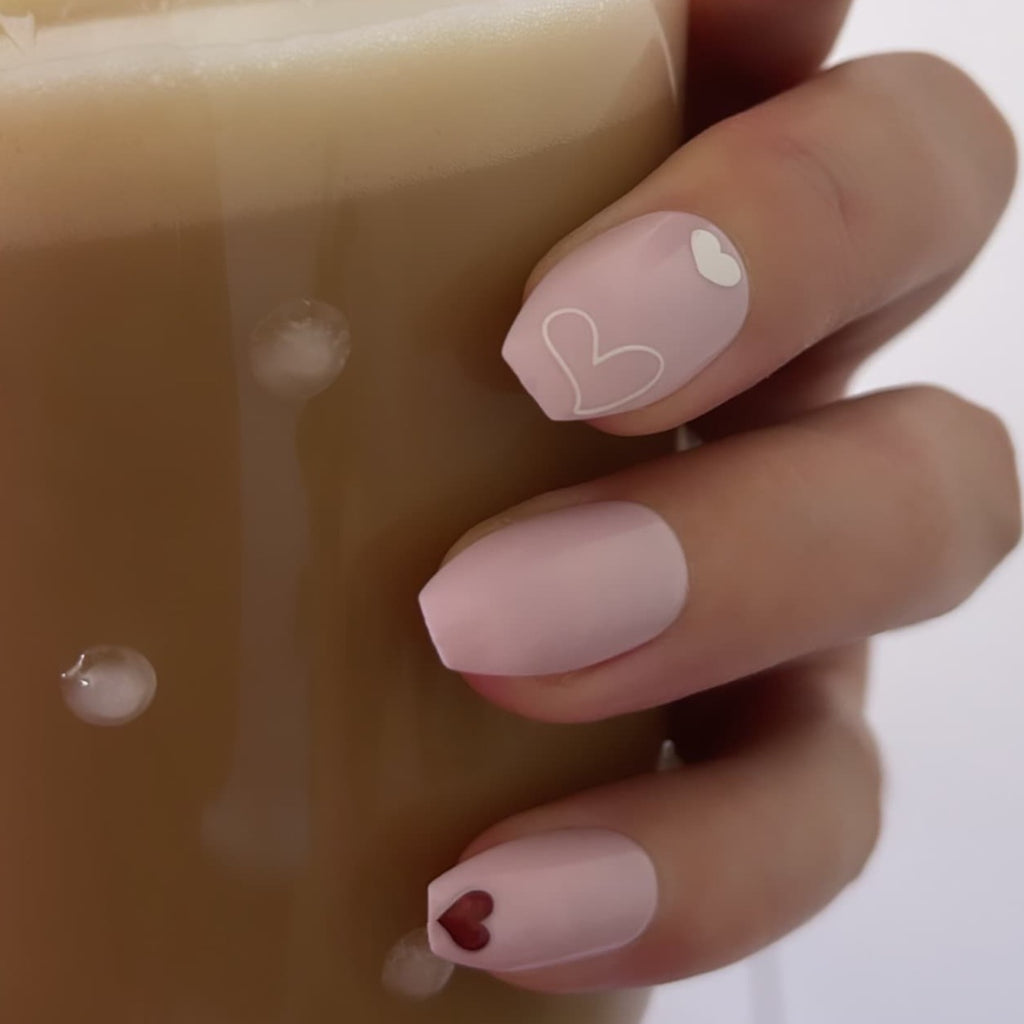 Close up of Instant Mani Co. heart shaped nail stickers holding coffee cup
