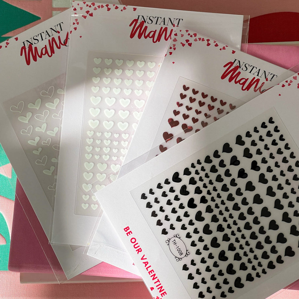 Instant Mani Co. Heart shaped nail stickerS sitting on pink books