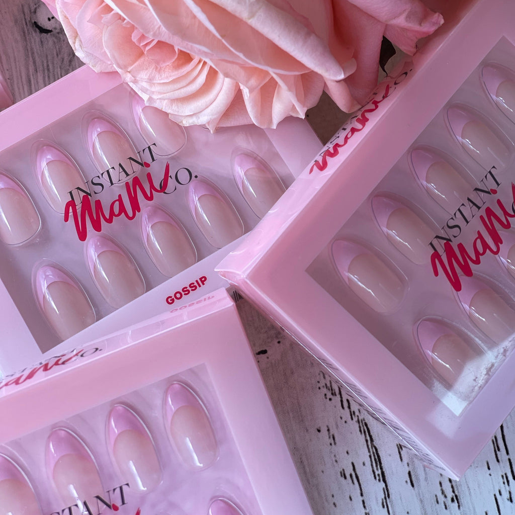 Instant Mani Co. pink tip Gossip deep french press on nails next to roses. 