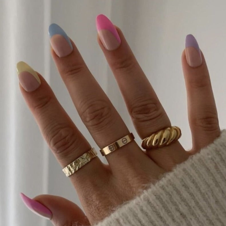 Girl wearing Instant Mani Co. Tipsy press on nails with gold rings and fluffy jumper