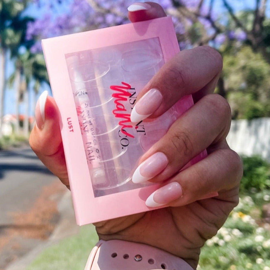 Girl holding Instant Mani Co. Press on Nails case while wearing Instant Mani Co. Lust press on nails