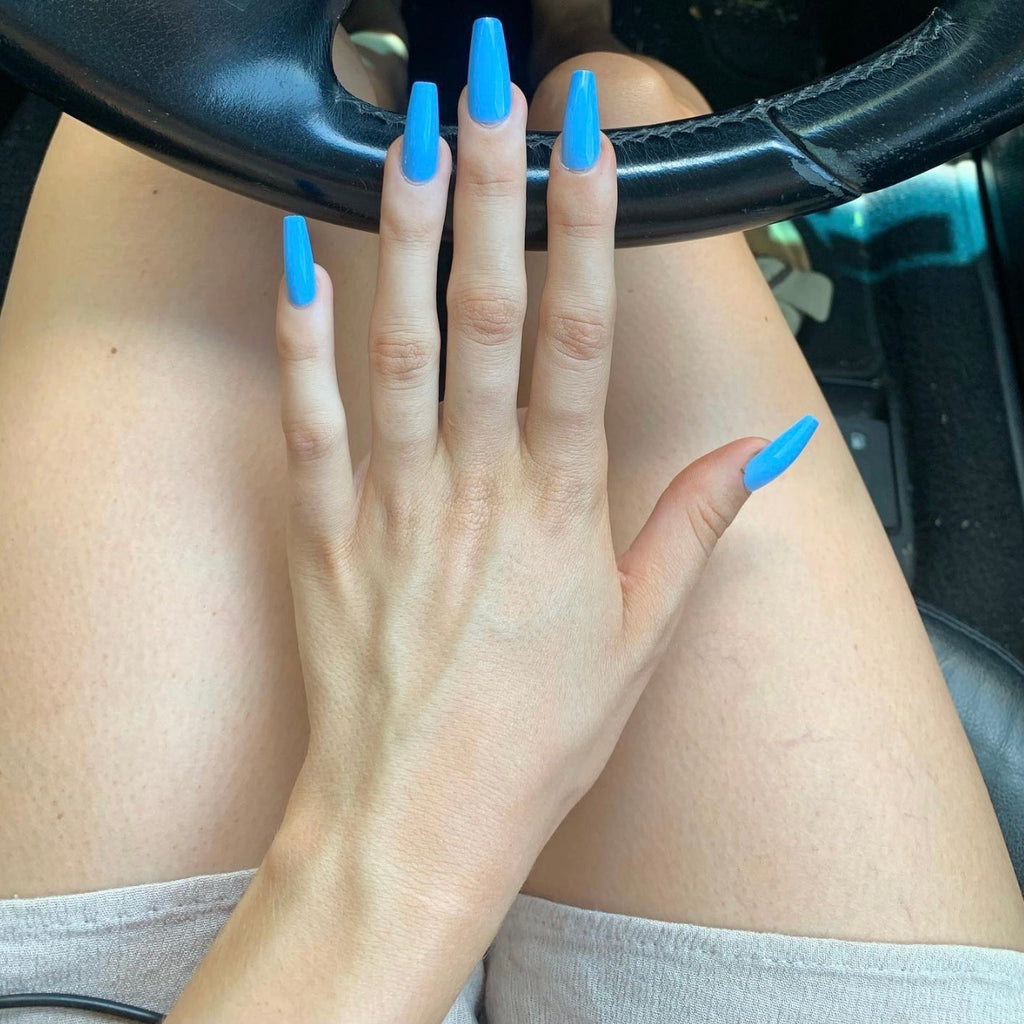Girl wearing Blue press-on nails by Instant Mani Co in car 
